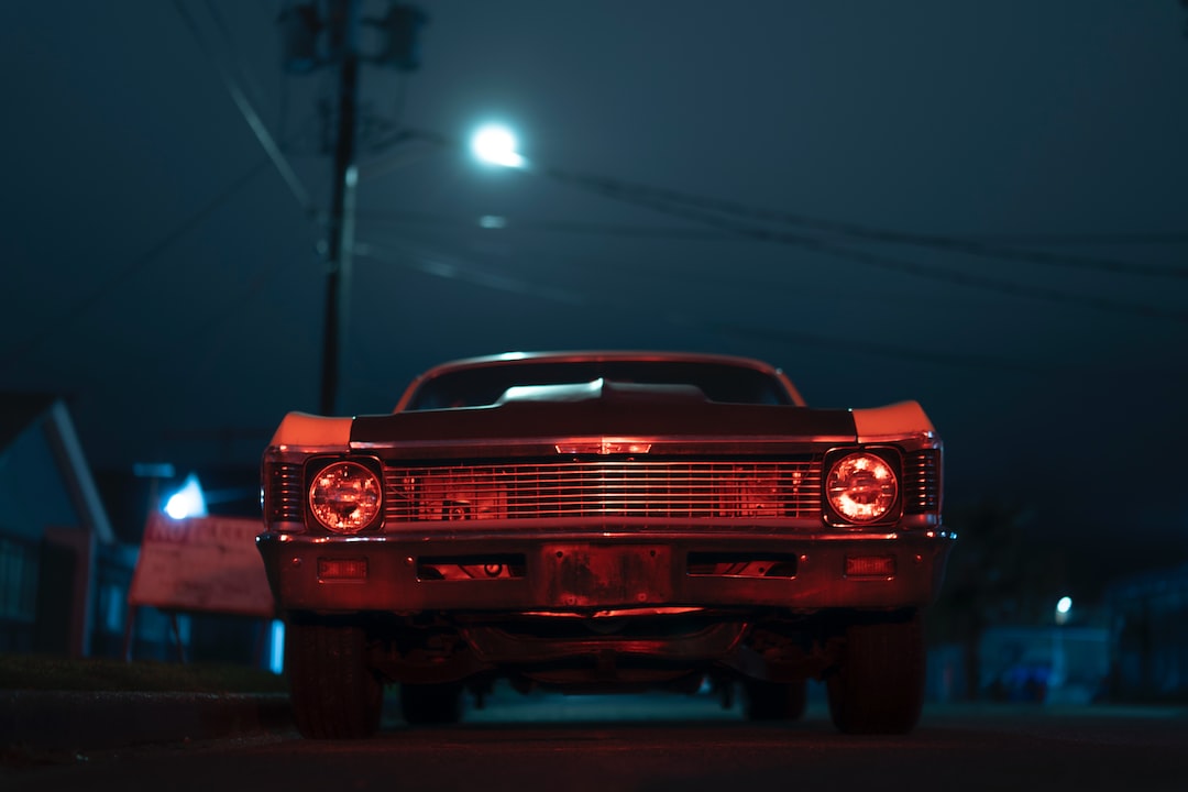 red chevrolet camaro on road during nighttime