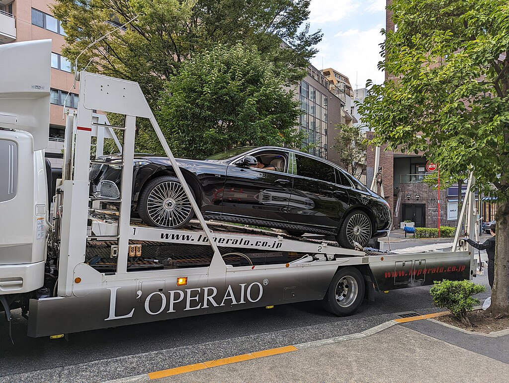 Black luxury car on back of a single unit car hauler