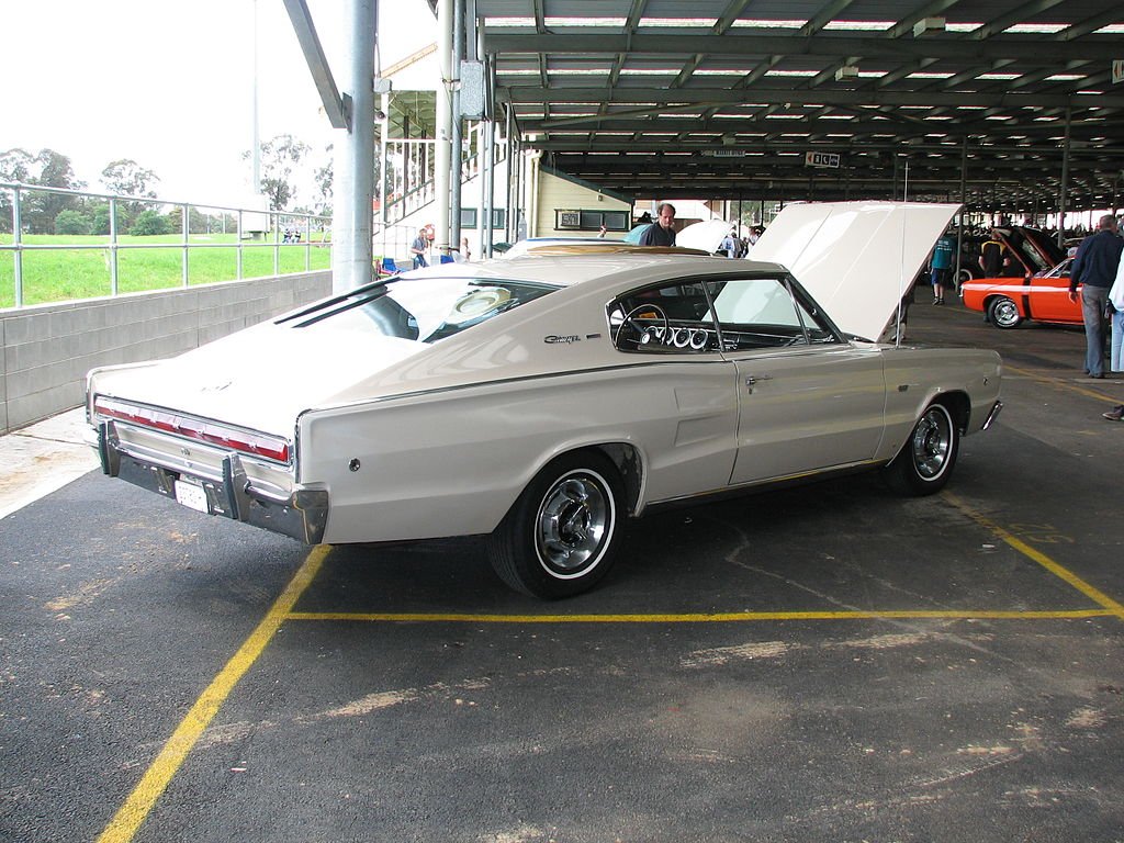 1966 dodge charger parked at a car show with its hood raised