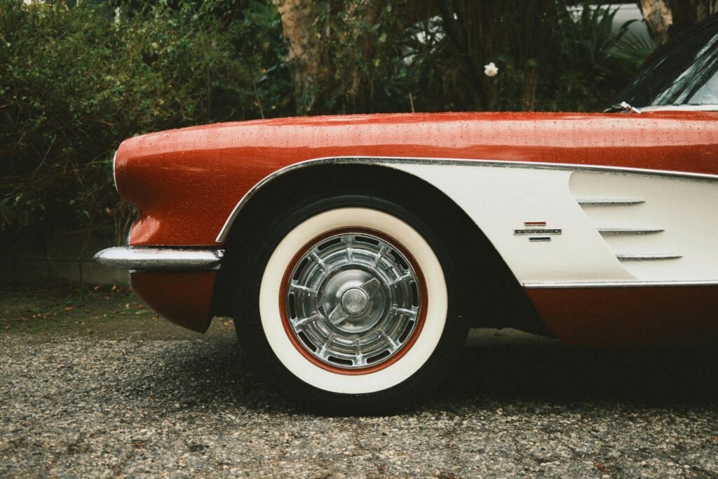 Front driver's quarter panel and tire on a classic red and white Chevy Corvette.